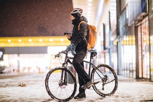 Person standing with a bicycle outdoors