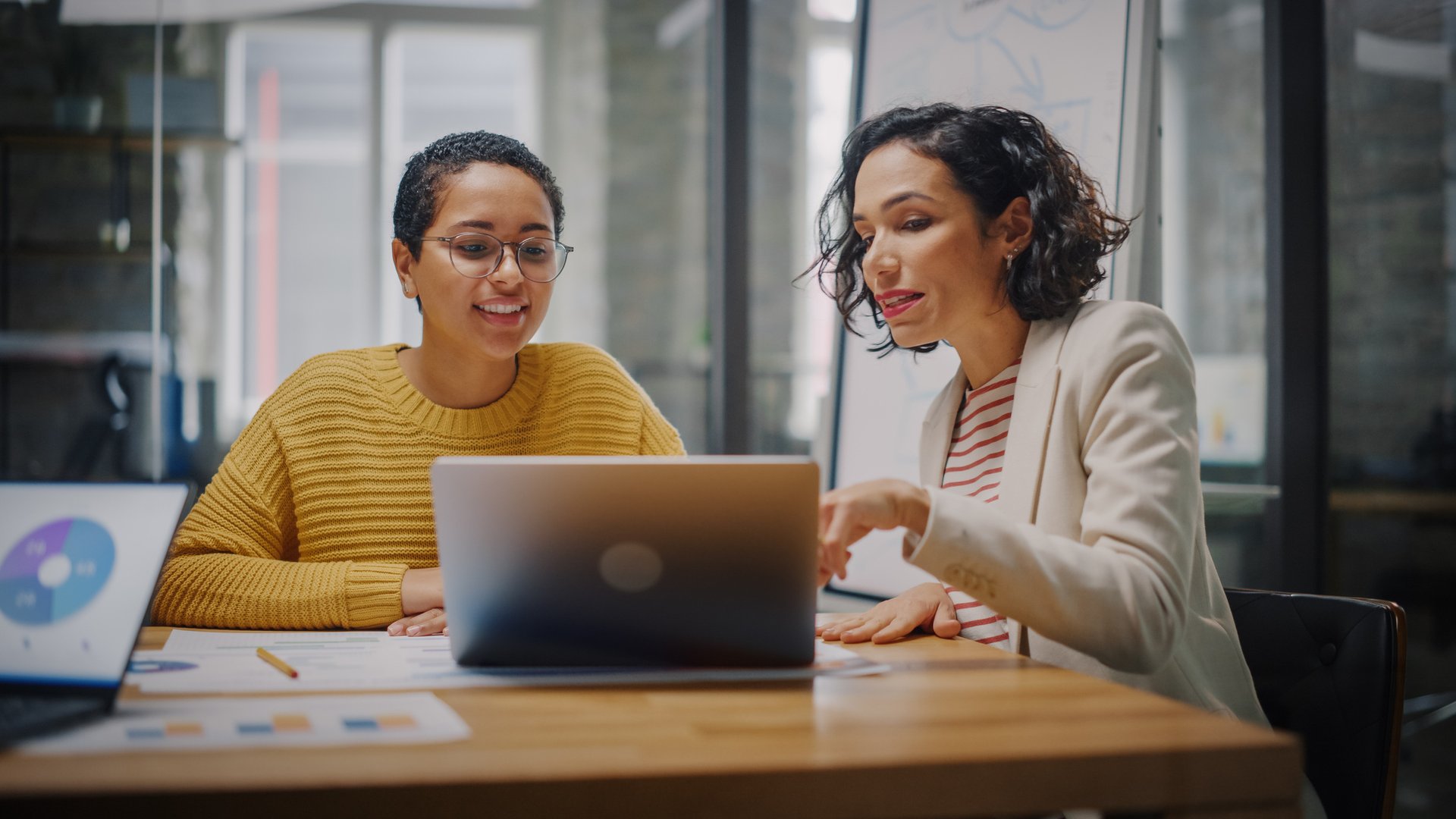 Women working on pay equity analysis at a laptop.